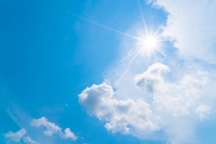 Cielo azul con un sol y nubes